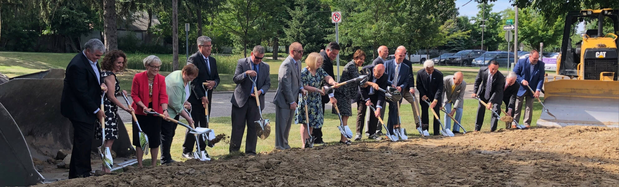 Twenty people from the Flint community shoveling dirt for the ceremonial groundbreaking of Flint Cultural Center Academy.